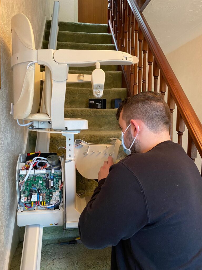 An Engineer on an at-home visit, servicing a stairlift.