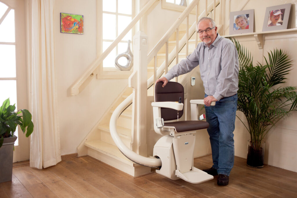 A Stairlift, curved at the bottom, in a modern, well-lit home.