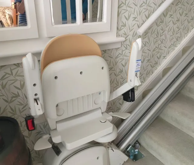 A rented stairlift at the bottom of the stairs.