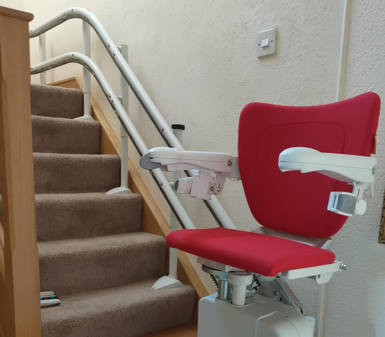 A narrow Staircase with a Stair lift installed.