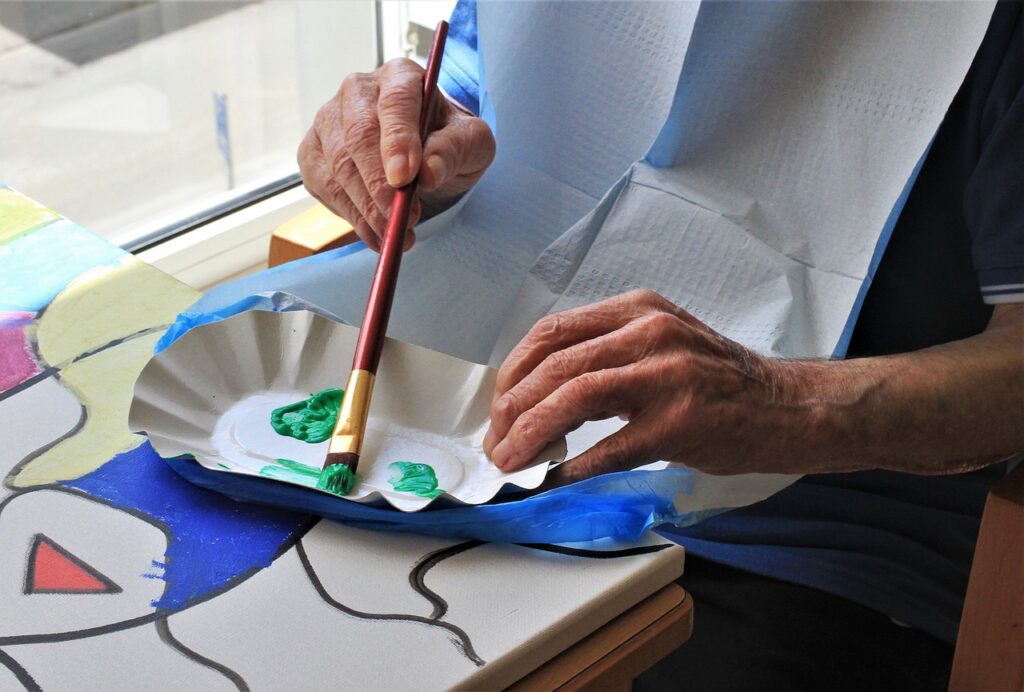 Senior artist mixing green paint.