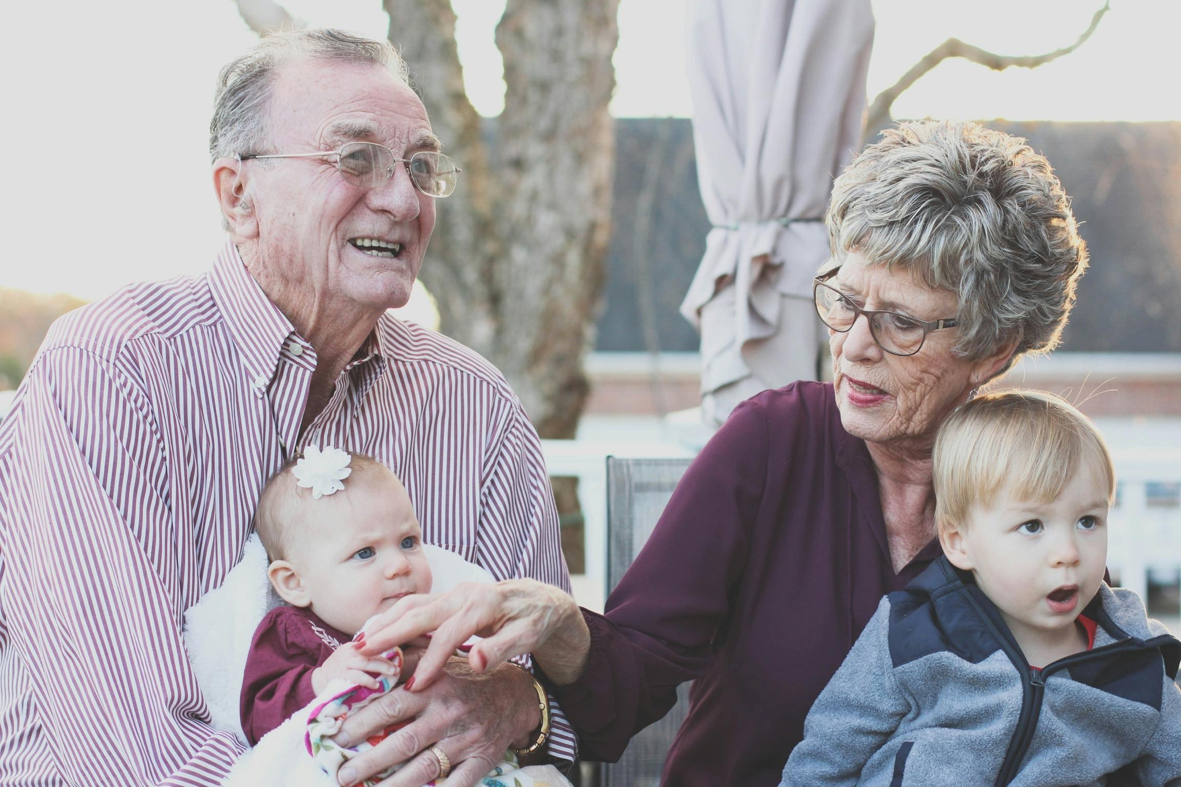 Senior Couple happily holding their grandchildren