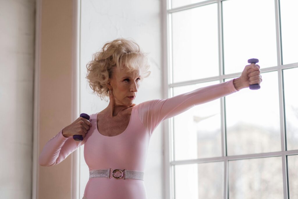 A Elderly Woman in Pink Leotards doing power training
