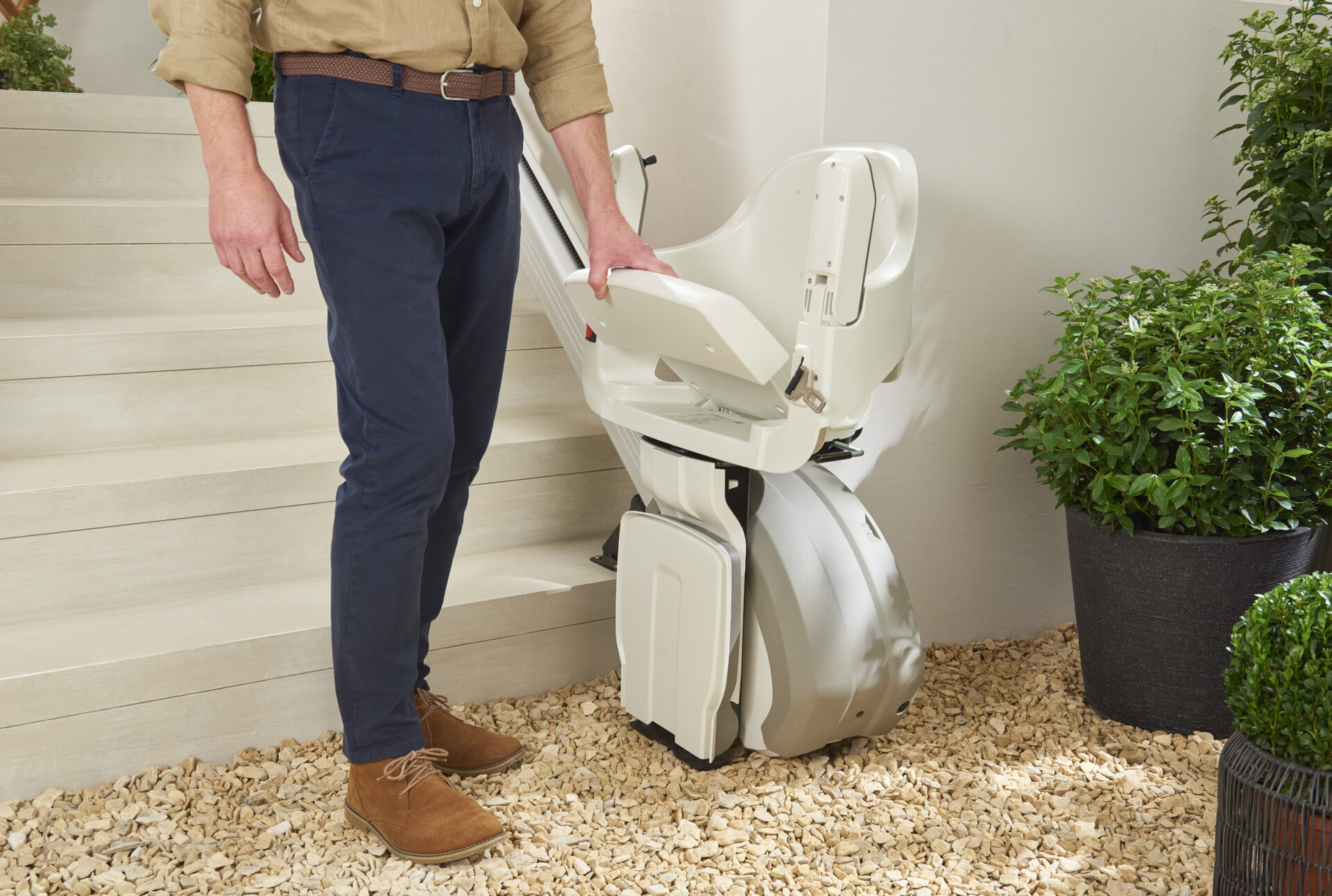 An older man using the convenient fold down seat on the homeglide outdoor stairlift